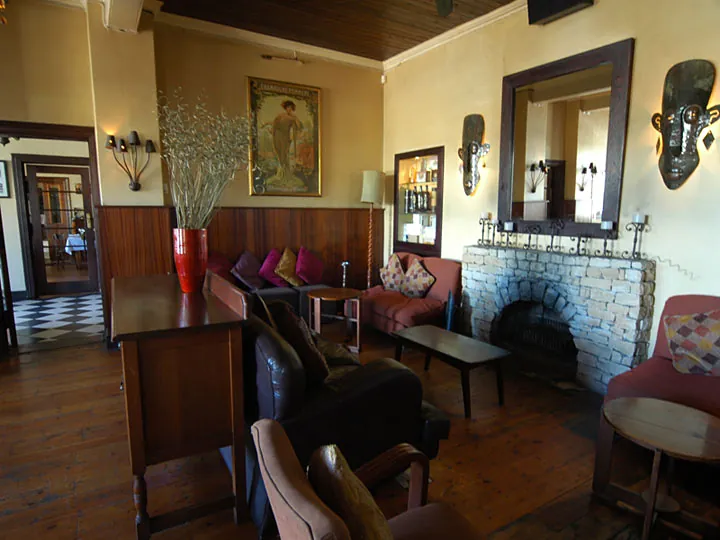 The lounge with its stone fireplace, leather chairs and art on the walls
