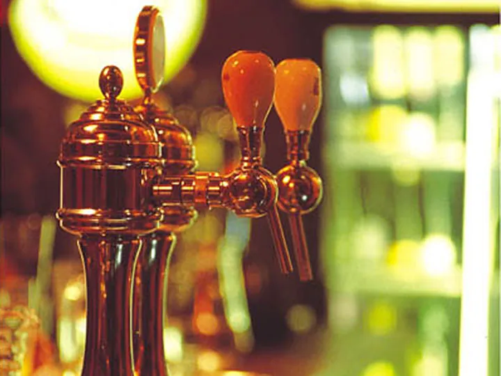 Brass beer taps glowing at the bar