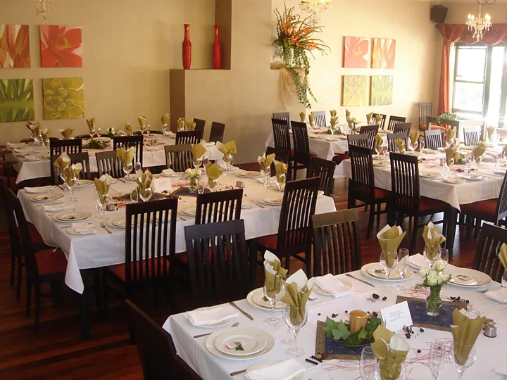 Tables laid with white cloths and folded napkins for a celebration
