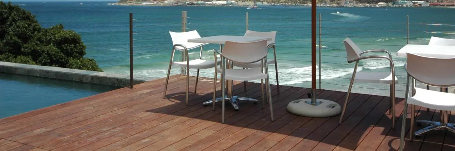White chairs on the timber deck above the beach and the Atlantic