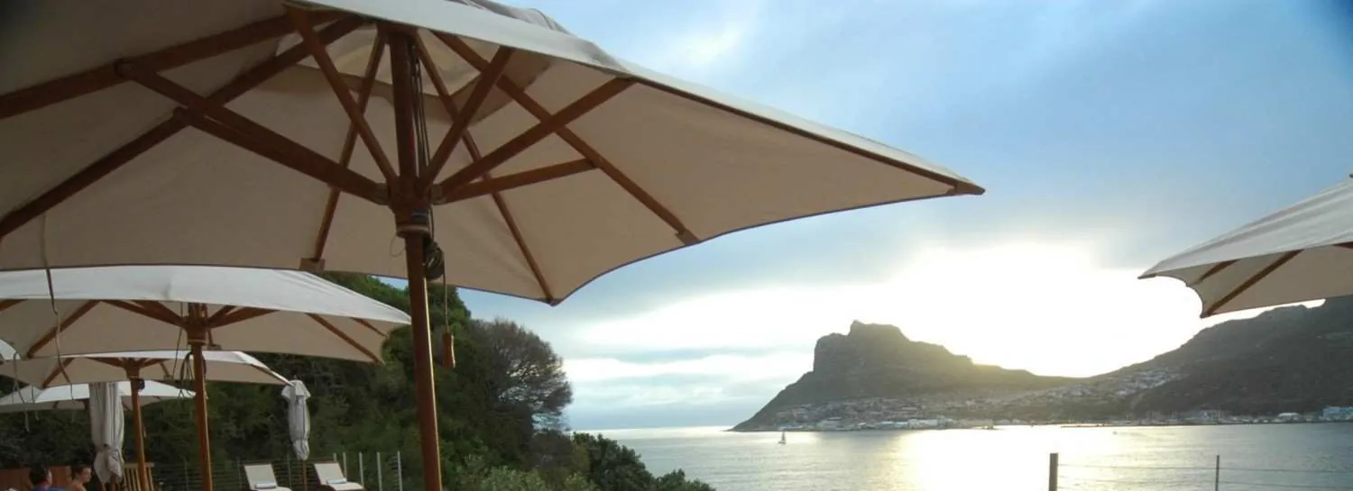 Terrace umbrellas against the afternoon light over the Sentinel
