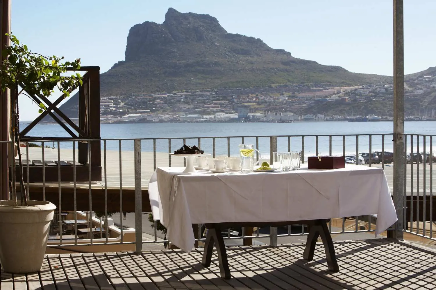 A table set for tea on the Sentinel Room's private deck, with the bay and the Sentinel beyond